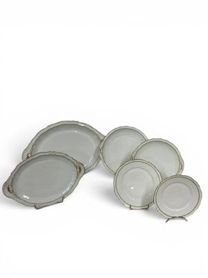 six assiettes en porcelaine blanche, avec des bords argentés sur fond blanc