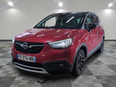 L'Opel rouge est garée dans une grande pièce dont le sol est en damier.