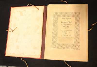 an open book sitting on top of a black cloth covered table
