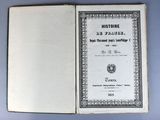an old book with a black and white cover on a blue surface