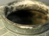 a close up of a vase with a lot of dirt on it