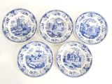 quatre assiettes bleues et blanches sur lesquelles est représentée une ville