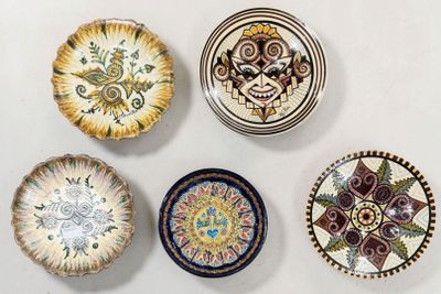 Plusieurs assiettes décoratives sont disposées sur une surface blanche