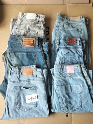 deux paires de jeans bleus posées sur une boîte en carton