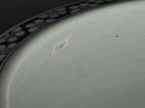 a white plate with a black border and a sticker on it