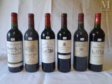 six bottles of wine are lined up on a table