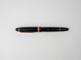 a black and gold pen sitting on top of a white surface
