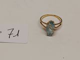une bague en or sertie d'une pierre verte, avec une étiquette de prix