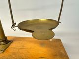 a metal scale with a wooden base on a white background