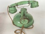 a green telephone that is sitting on a table