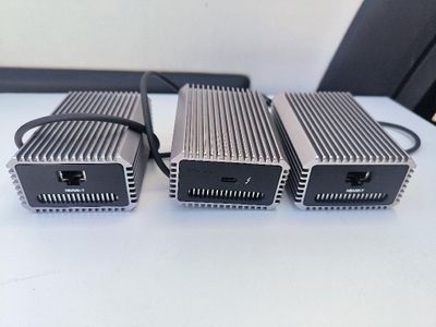 trois blocs d'alimentation posés sur une table blanche, à côté d'une chaise noire
