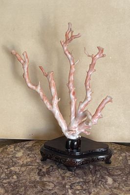 un vase noir orné d'un arbre blanc, posé sur une table en marbre