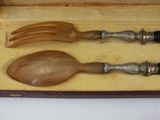 two wooden spoons and a fork in a box