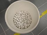 a white bowl filled with white balls on a tiled floor