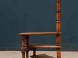 an old wooden chair sitting on top of a floor next to a blue wall