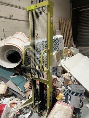 a large pile of trash in a warehouse with a machine