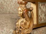 a gold couch with a statue on top of it