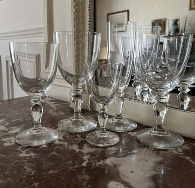 several empty wine glasses sitting on top of a counter next to a mirror