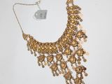 un gros plan d'un collier en or orné de pièces de monnaie