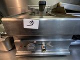 stainless steel counter top in a commercial kitchen with a sign on it