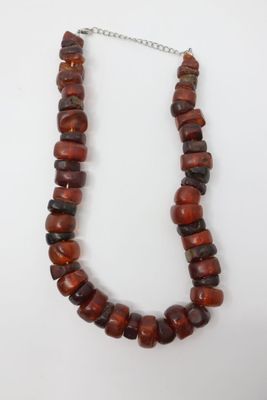 un collier composé de perles rouges et noires, avec une chaîne en argent