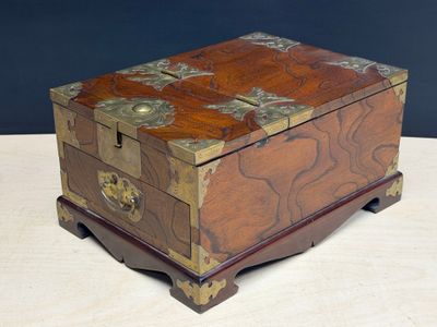 une petite boîte en bois posée sur une table, sur fond noir