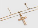 a gold necklace with a cross and a chain on a white background
