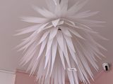 a white light hanging from the ceiling in a pink room