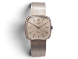 une photo d'une montre-bracelet argentée posée sur une surface blanche