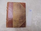 un petit livre à la couverture marron posé sur une table