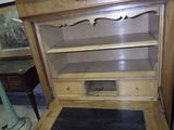 une bibliothèque en bois surmontée d'une porte vitrée