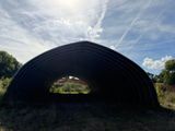 a large black structure sitting in the middle of a field
