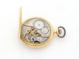 a small gold pocket watch on a white surface
