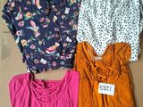 three tops are on a cardboard box with a price tag