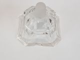 a clear glass candle holder on a white table
