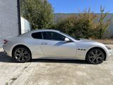 a white mas car parked in front of a building