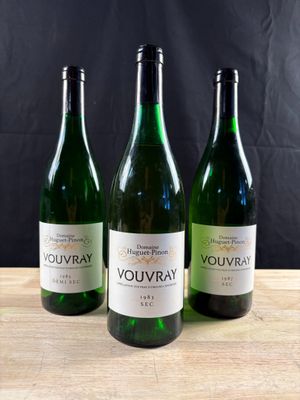 three bottles of wine sitting on top of a wooden table