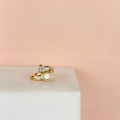 a close up of a gold ring with two diamonds on top of a block