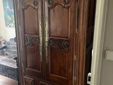 une grande armoire en bois dans le coin d'une pièce