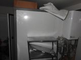 a white refrigerator in the corner of a room with a towel on top of it