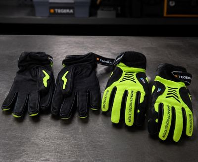 three pairs of black and yellow gloves sitting on top of a table