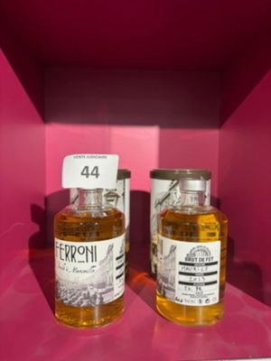 deux bouteilles d'alcool sont posées sur une étagère, dans une boîte rose