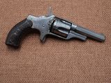 a close up of a revolver on a brown background