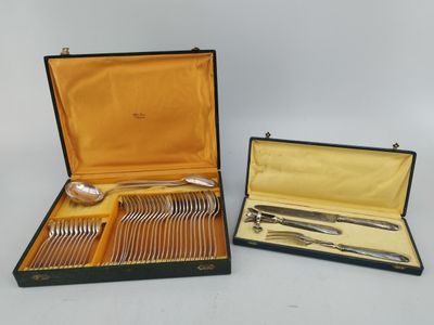deux sets d'argenterie dans un coffret sur une table