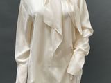 an image of a mannequin wearing a white blouse and white pants
