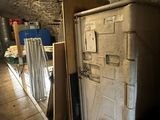 a refrigerator in the middle of a room with a lot of boxes