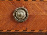 a wooden dresser with a metal knob on top of it