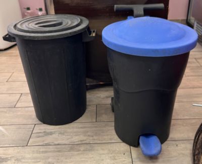 deux poubelles posées l'une à côté de l'autre sur le sol