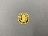 a close up of a gold coin on a gray surface