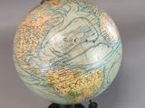 a small globe on a black stand with a map on it